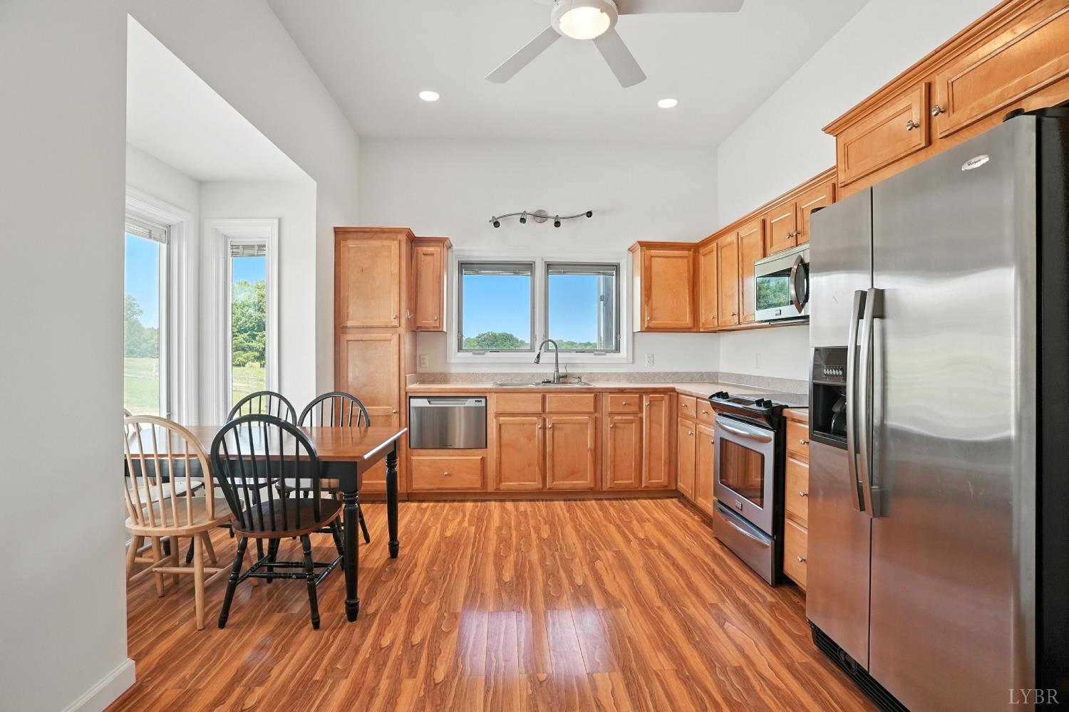 1433 Piney Mountain Road Appomattox, VA 24522 - Photo 19 of 68 a kitchen with stainless steel appliances granite countertop a refrigerator a stove a sink dishwasher with a dining table and chairs with wooden floor