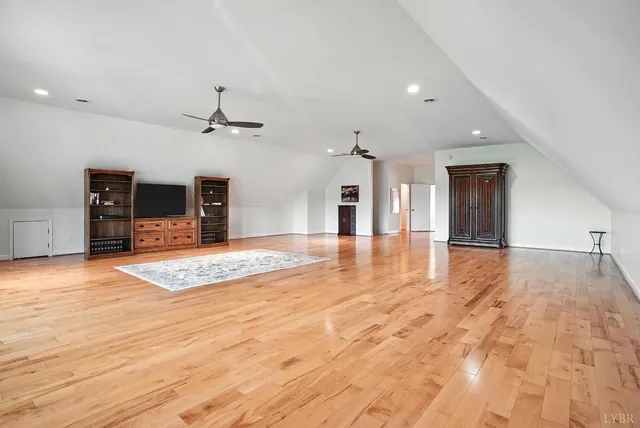 a view of empty room with wooden floor and bench