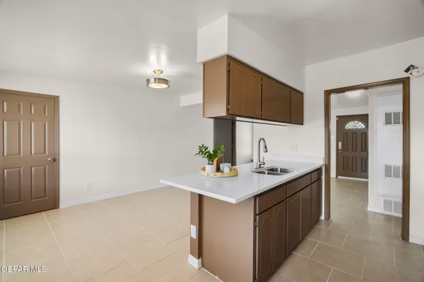a kitchen with a sink vanity and a mirror