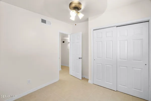 a view of a chandelier fan and closet area