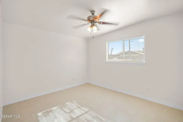 an empty room with a window and a ceiling fan