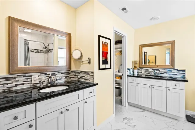 a bathroom with a granite countertop sink and a mirror