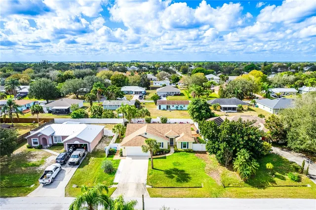 an aerial view of a house with a garden and trees