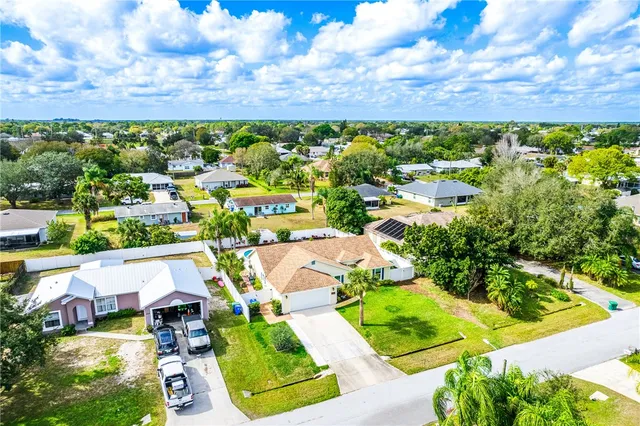 an aerial view of residential houses with outdoor space and swimming pool