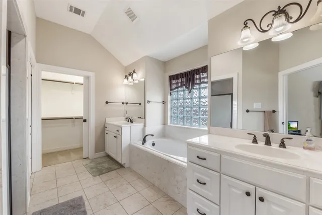 a bathroom with a bathtub sink and mirror