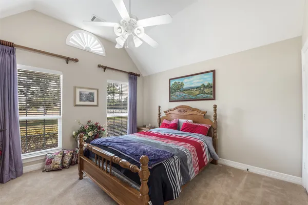 a bed sitting in a bedroom next to a window