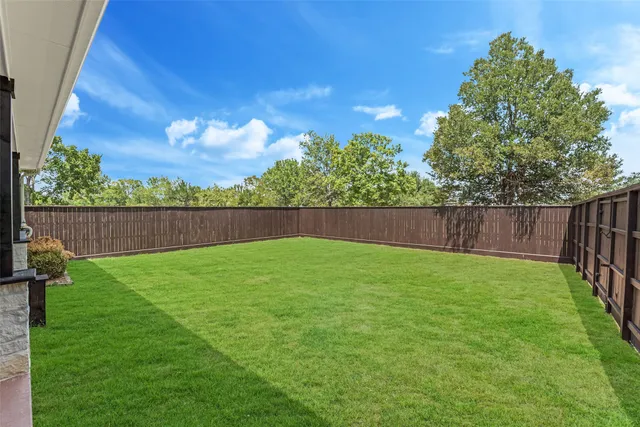 a view of yard with swimming pool and wooden fence