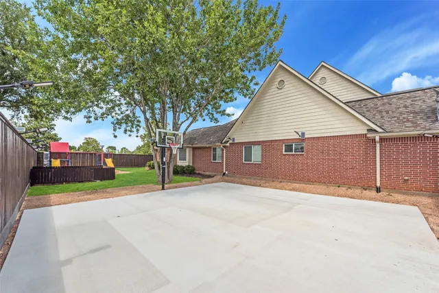a view of a house with a yard and large tree