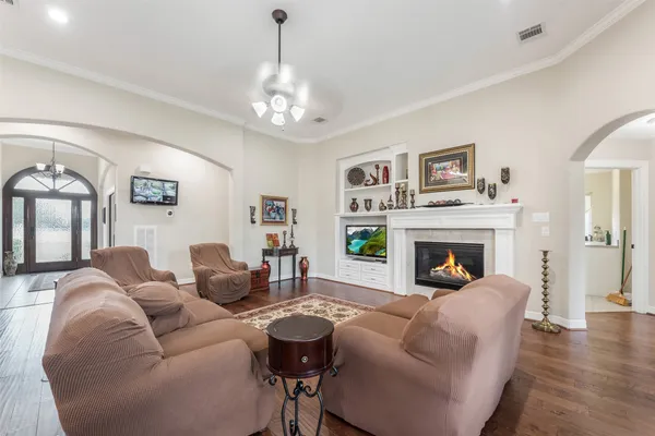 a living room with furniture a chandelier and a fireplace