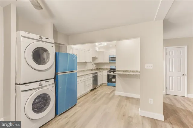 a kitchen with a washer and dryer with wooden floor