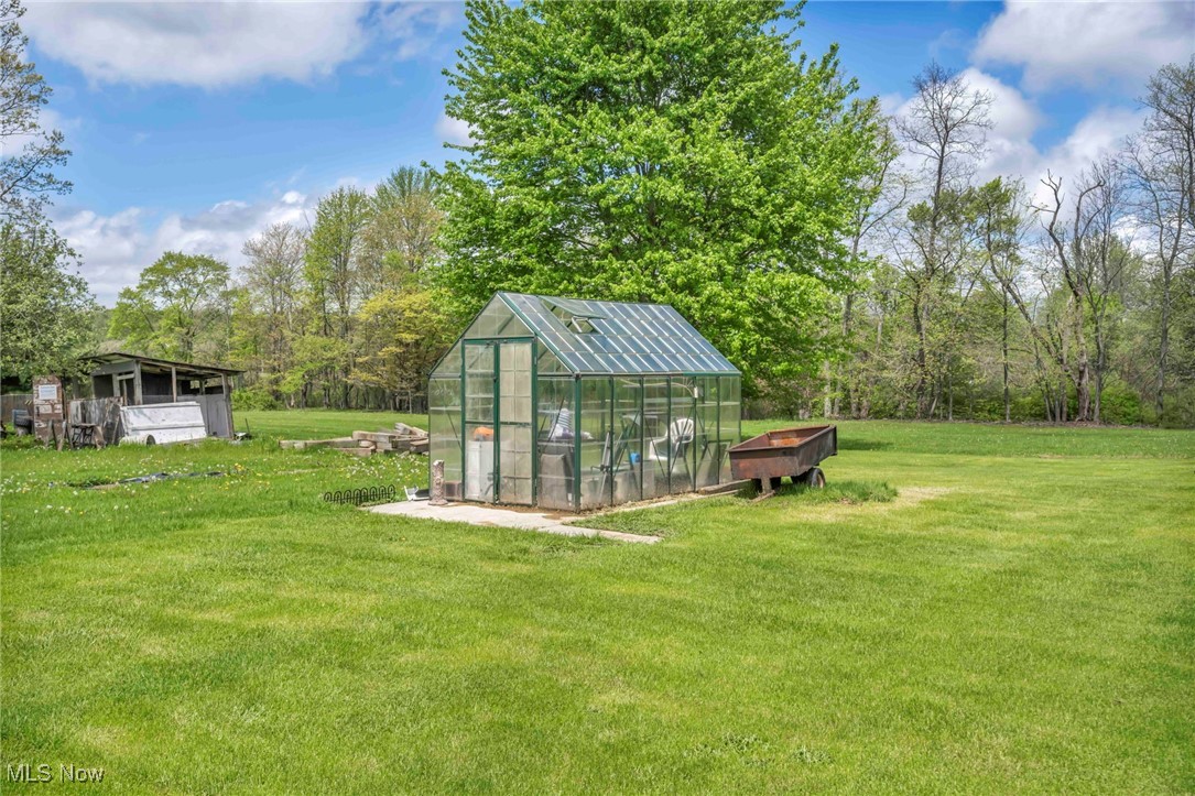 6873 Nichols Road Windham, OH 44288 - Photo 31 of 33 View of green lawn with a greenhouse and an outdoor structure
