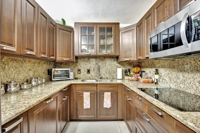 a kitchen with stainless steel appliances granite countertop a sink stove and cabinets