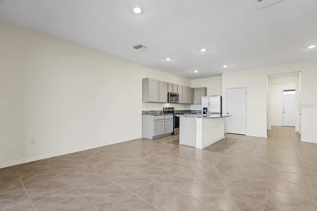 a view of kitchen with kitchen island and stainless steel appliances