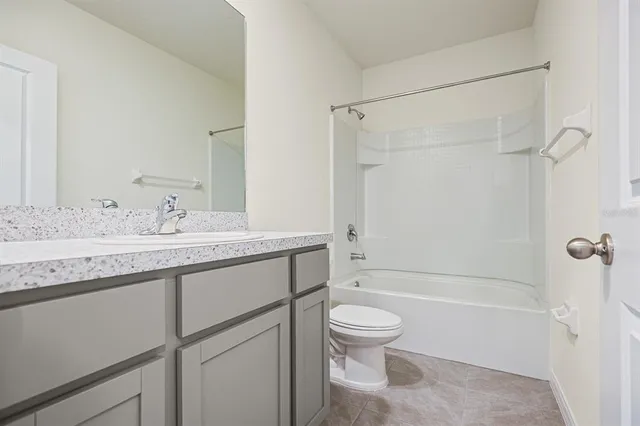 a bathroom with a granite countertop sink a toilet and shower
