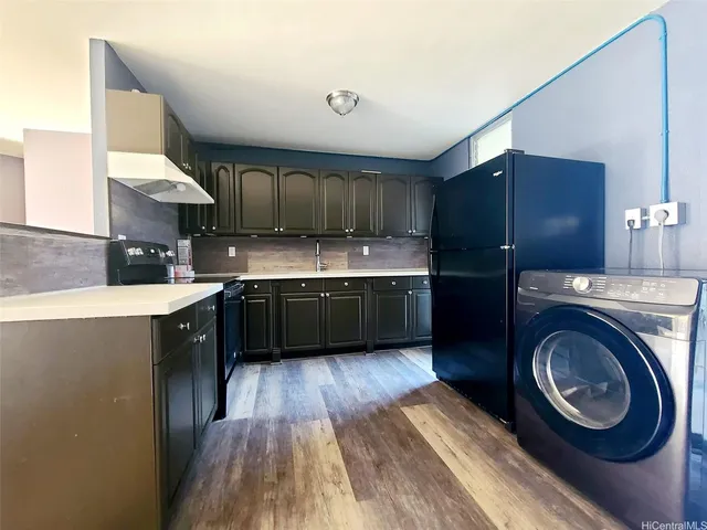 a kitchen with kitchen island granite countertop a sink stainless steel appliances and cabinets