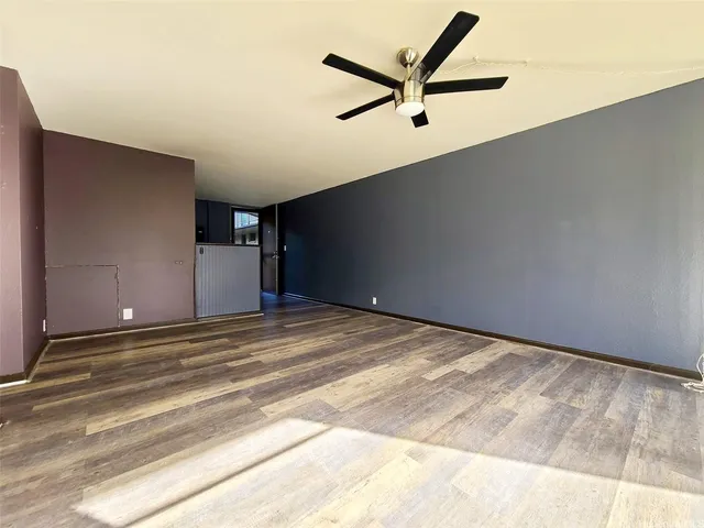 a view of a livingroom with a ceiling fan and wooden floor