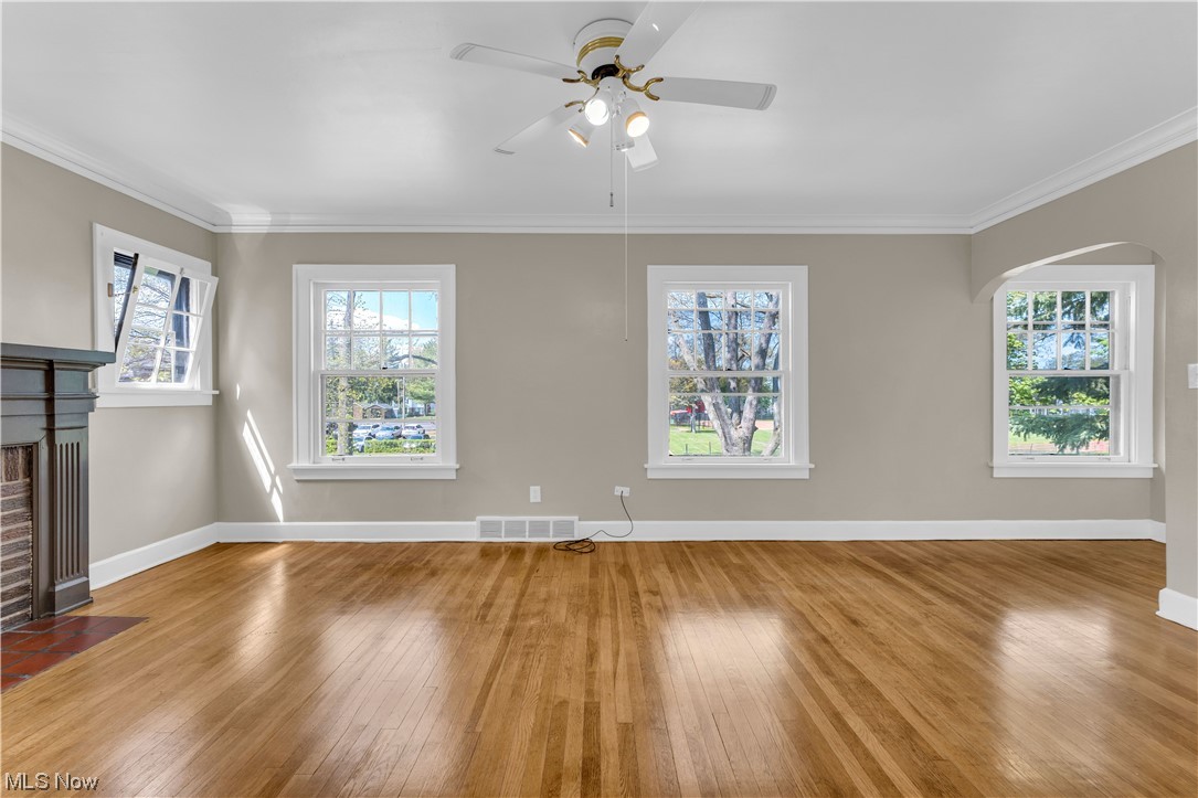 3609 Strandhill Road Shaker Heights, OH 44122 - Photo 4 of 47 Unfurnished living room featuring light hardwood / wood-style floors, ceiling fan, ornamental molding, and a brick fireplace