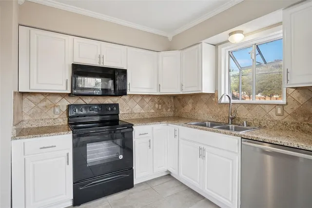 a kitchen with granite countertop cabinets stainless steel appliances and a sink