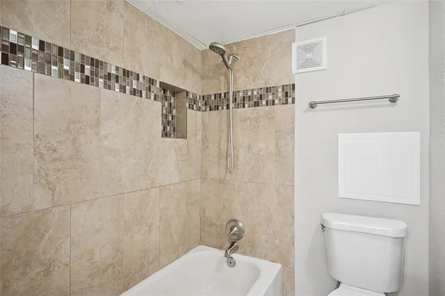 a bathroom with a shower a toilet and sink