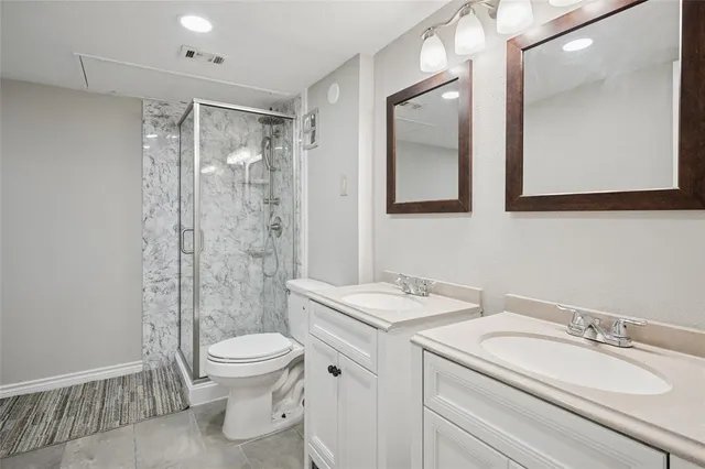a bathroom with a granite countertop sink toilet a mirror and shower