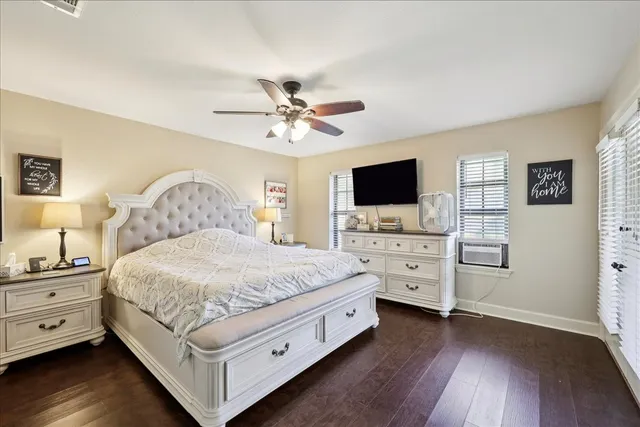 a spacious bedroom with a bed and a flat screen tv