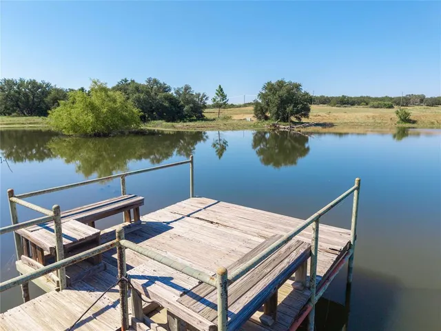 a view of a lake with couches chairs and wooden floor