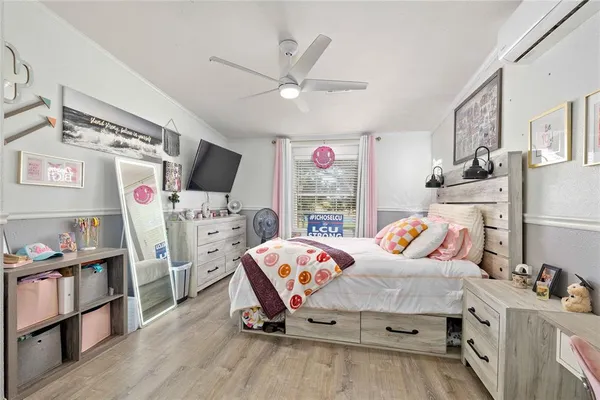 a bedroom with a bed and a table in it with chair