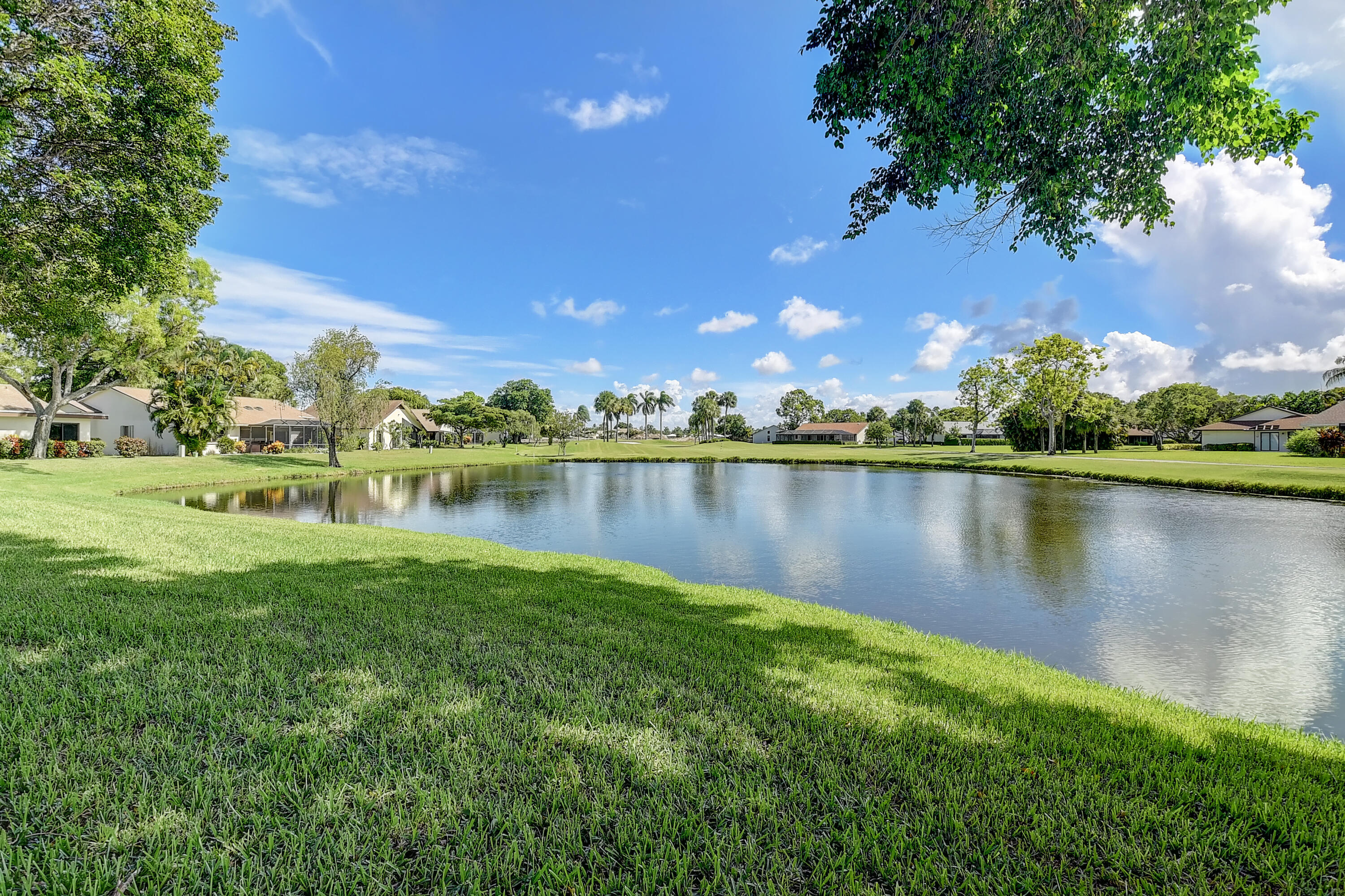 5642 Forest Oaks Terrace Delray Beach, FL 33484 - Photo 20 of 37 a view of a lake with houses in the back
