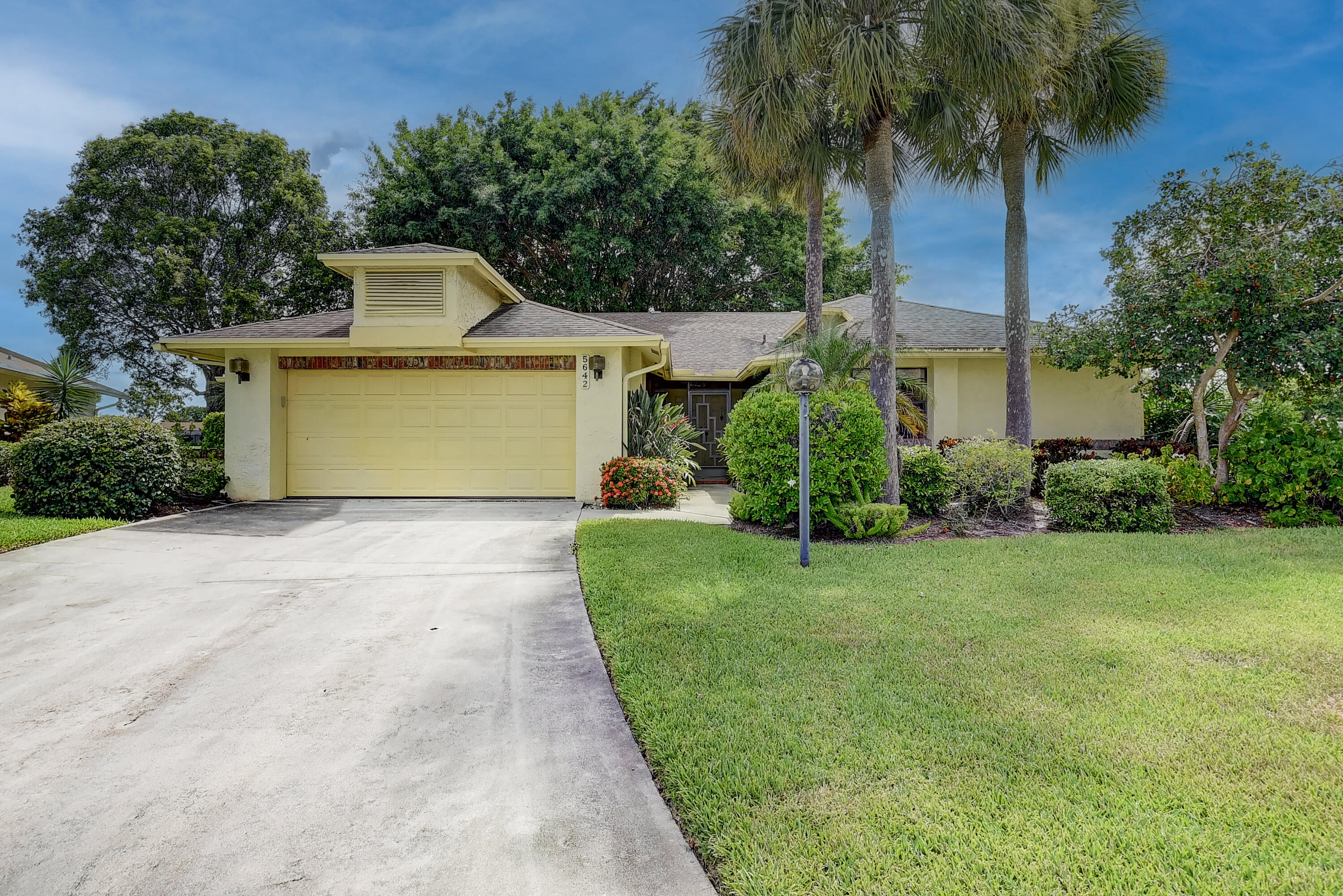 5642 Forest Oaks Terrace Delray Beach, FL 33484 - Photo 23 of 37 a front view of a house with garden