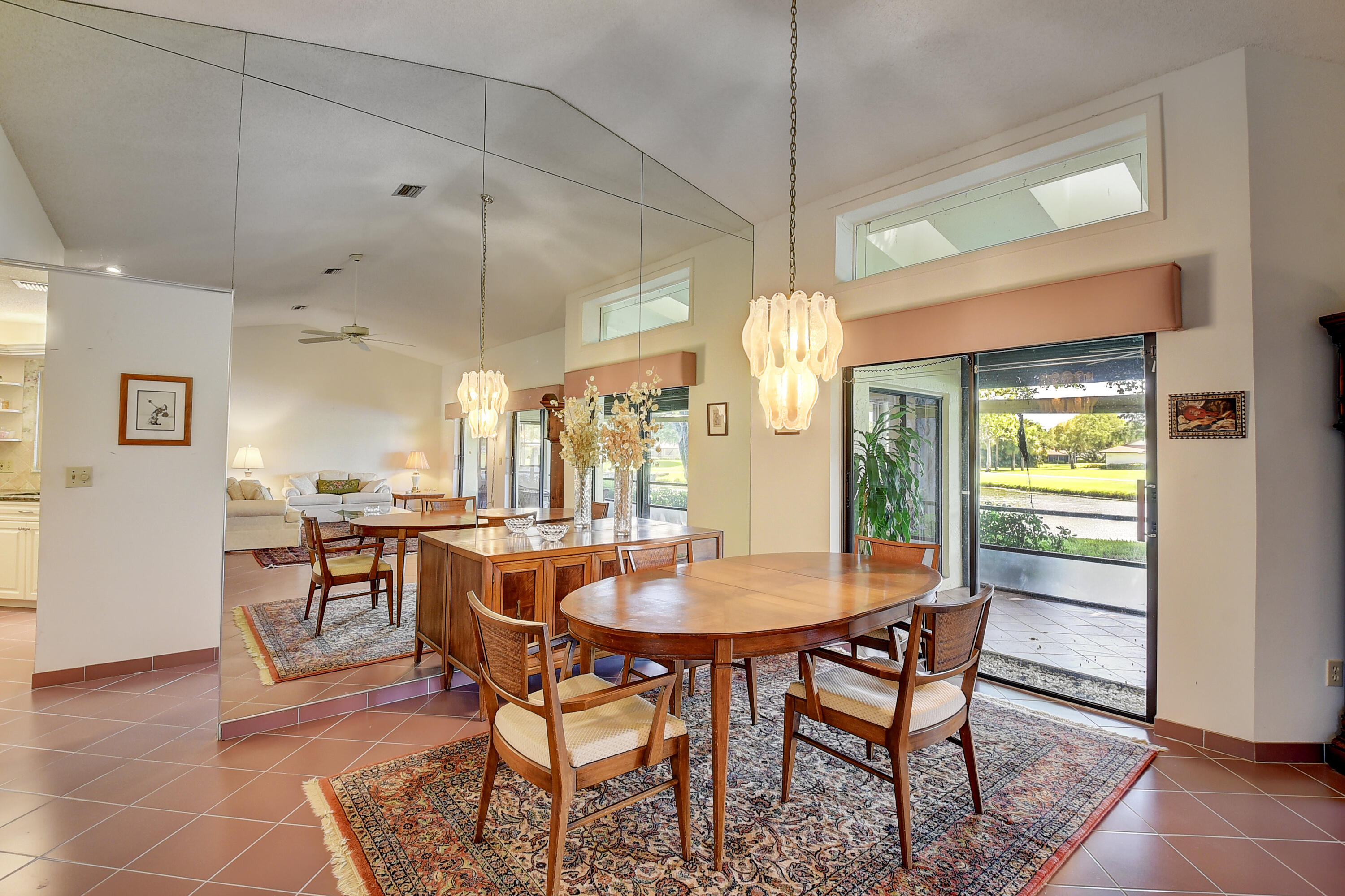 5642 Forest Oaks Terrace Delray Beach, FL 33484 - Photo 5 of 37 a dining room with furniture a chandelier and wooden floor