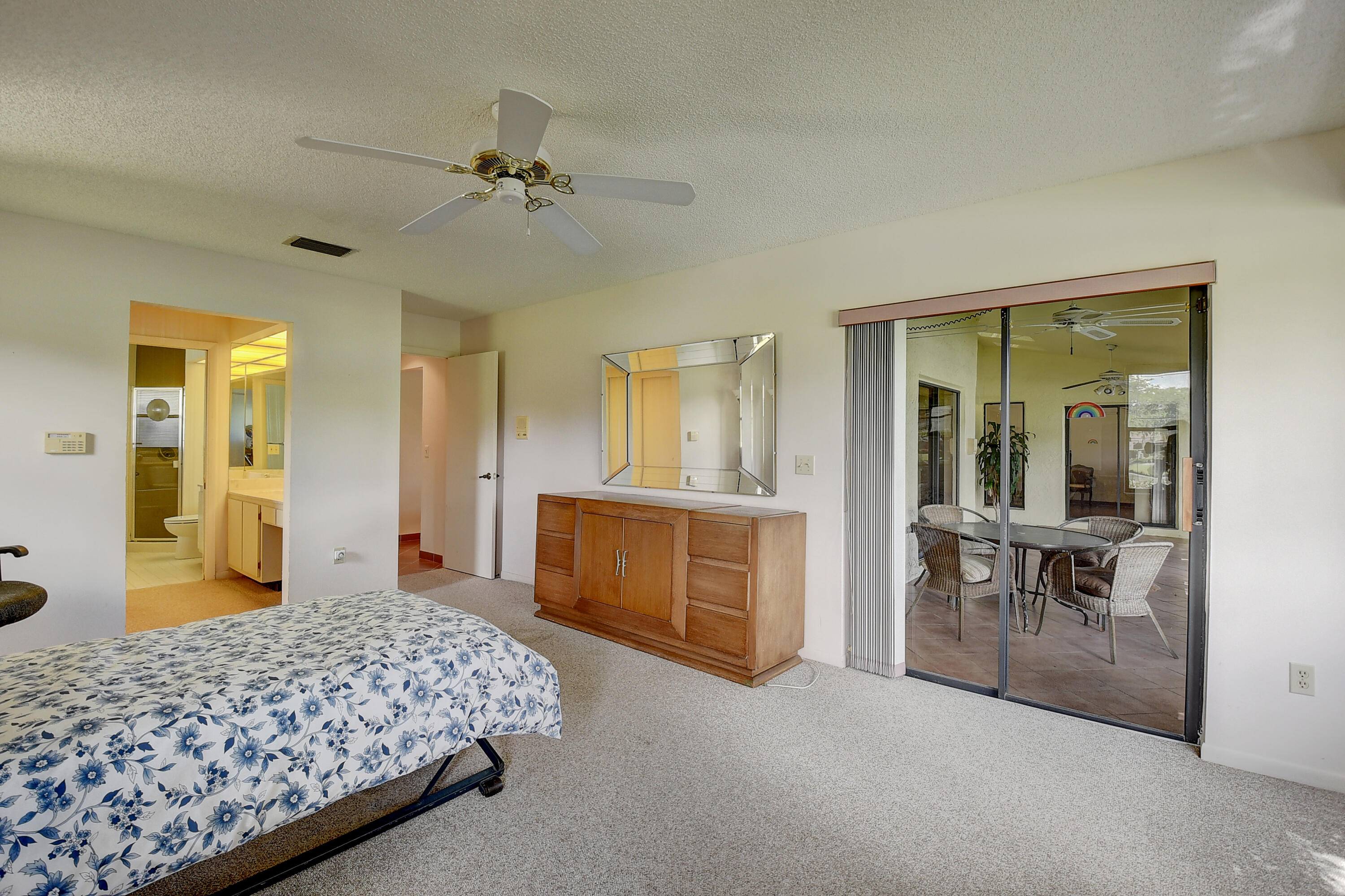 5642 Forest Oaks Terrace Delray Beach, FL 33484 - Photo 9 of 37 a bedroom with a bed and a chandelier