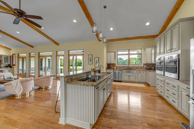 a living room with furniture a flat screen tv and a large window