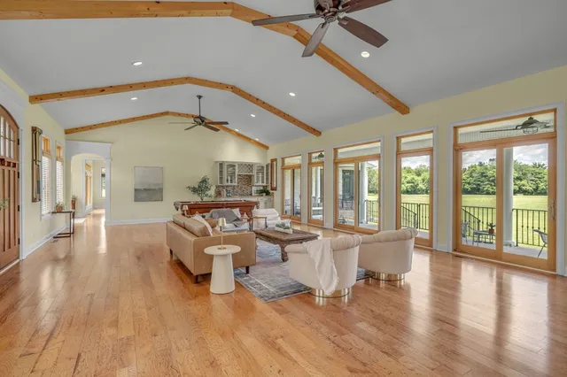 a very nice looking living room with a large window and wooden floor