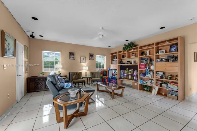 a living room with furniture a flat screen tv and a book shelf