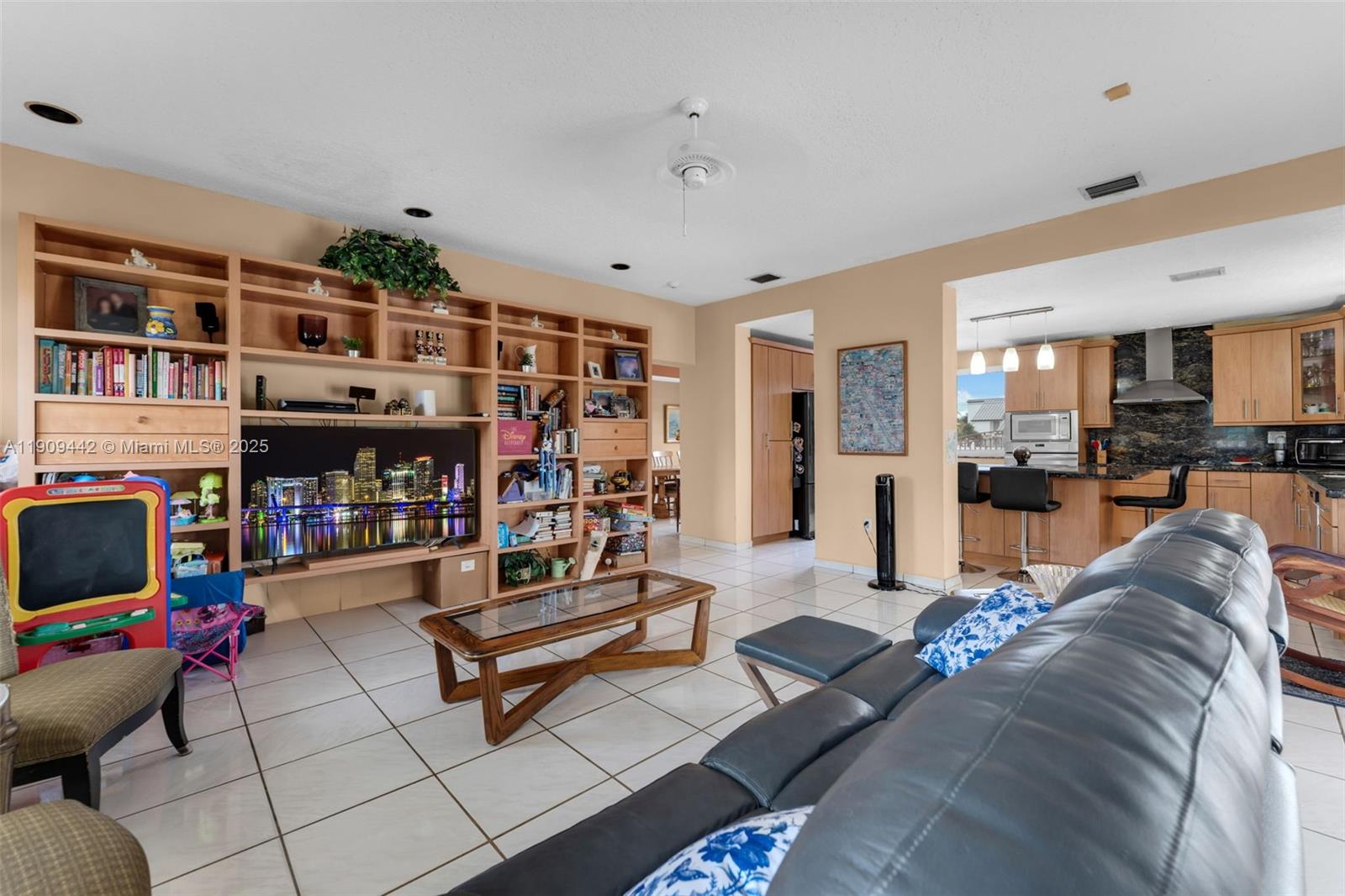 3200 Southwest 132nd Avenue Miami, FL 33175 - Photo 15 of 55 a living room with furniture a flat screen tv and a book shelf
