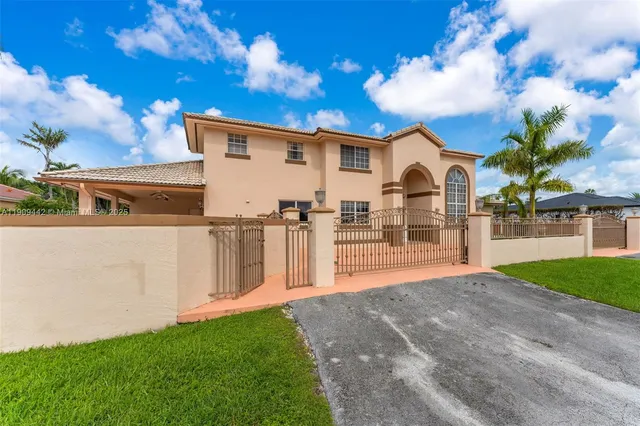 a view of a house with backyard and a tree