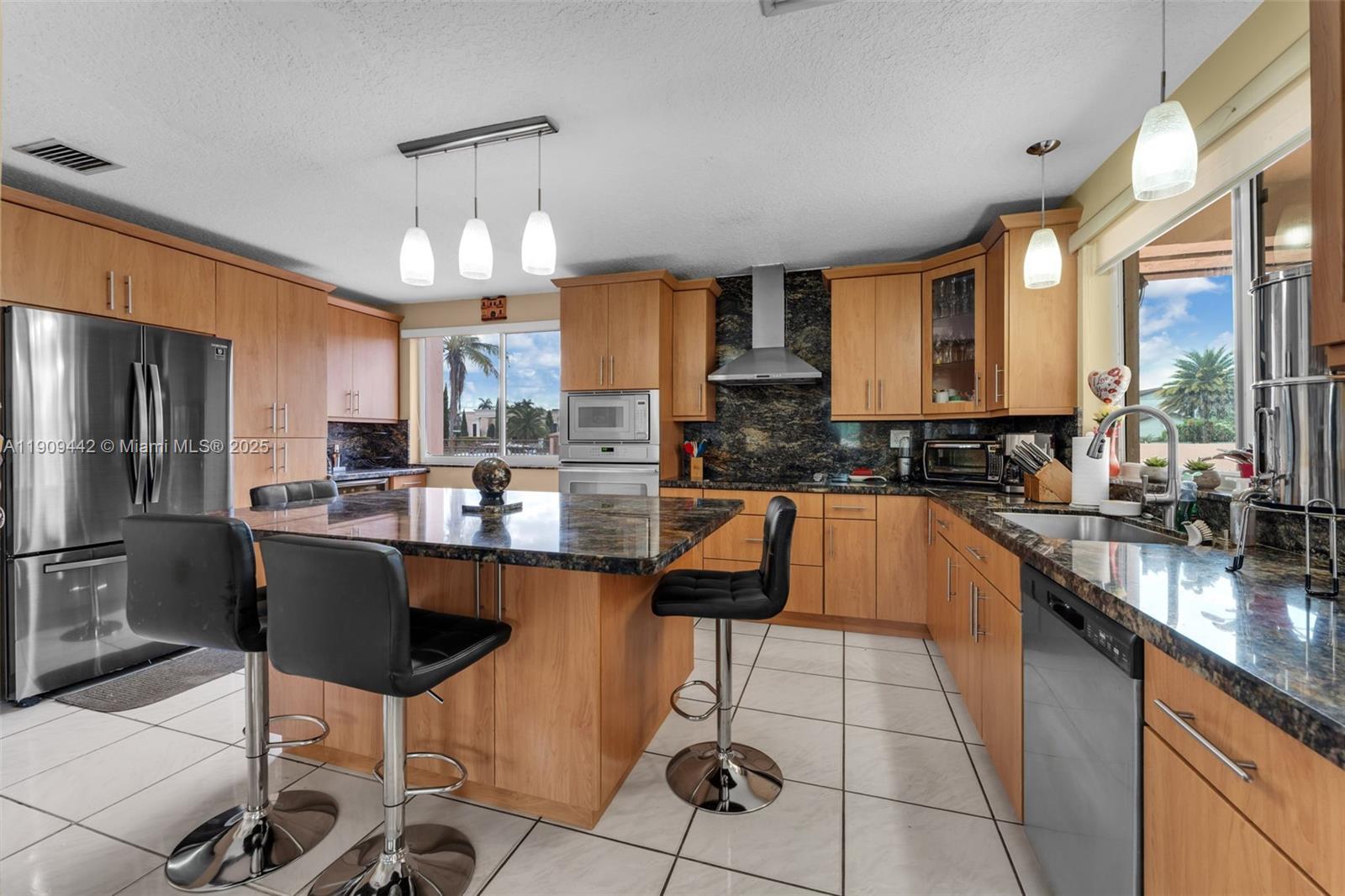 3200 Southwest 132nd Avenue Miami, FL 33175 - Photo 7 of 55 a kitchen with stainless steel appliances kitchen island granite countertop a sink and cabinets
