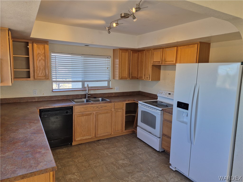 26432 Tamarisk Street, Unit STREET Meadview, AZ 86444 - Photo 14 of 60 Kitchen featuring dark countertops, white appliances, and wood finish cabinets