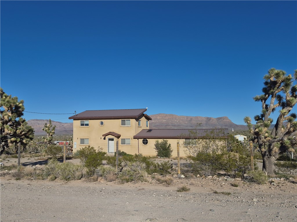 26432 Tamarisk Street, Unit STREET Meadview, AZ 86444 - Photo 2 of 60 View of front of house featuring a mountain view, stucco siding, and a metal roof