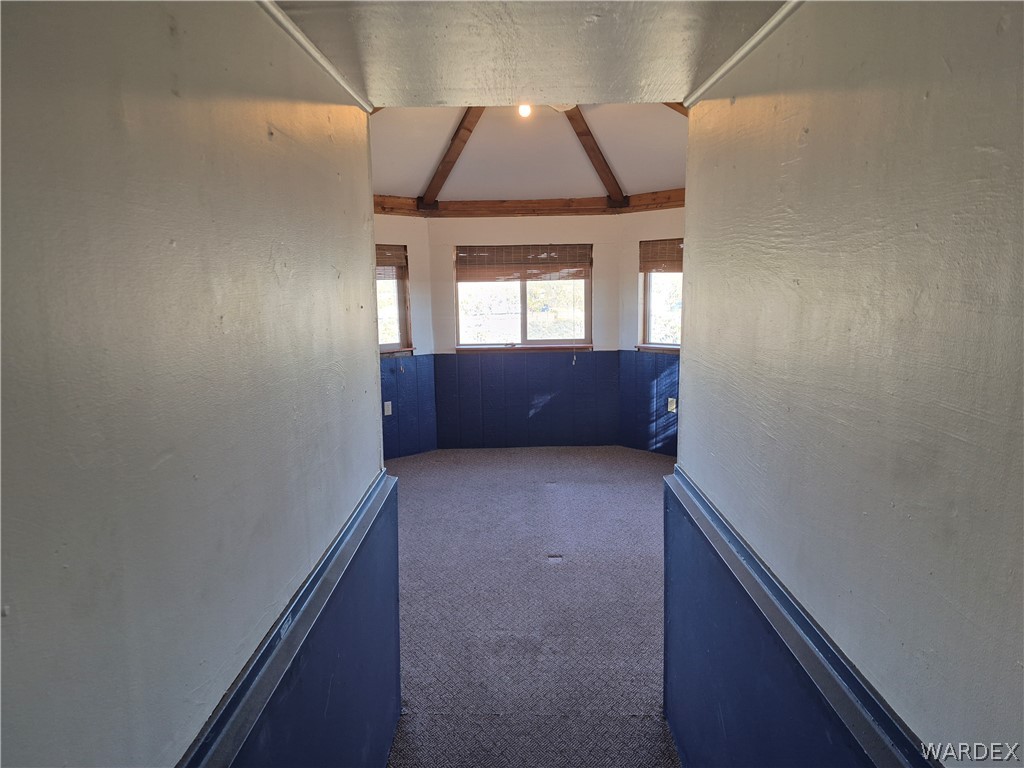 26432 Tamarisk Street, Unit STREET Meadview, AZ 86444 - Photo 21 of 60 Corridor featuring dark carpet, a textured wall, and lofted ceiling with beams
