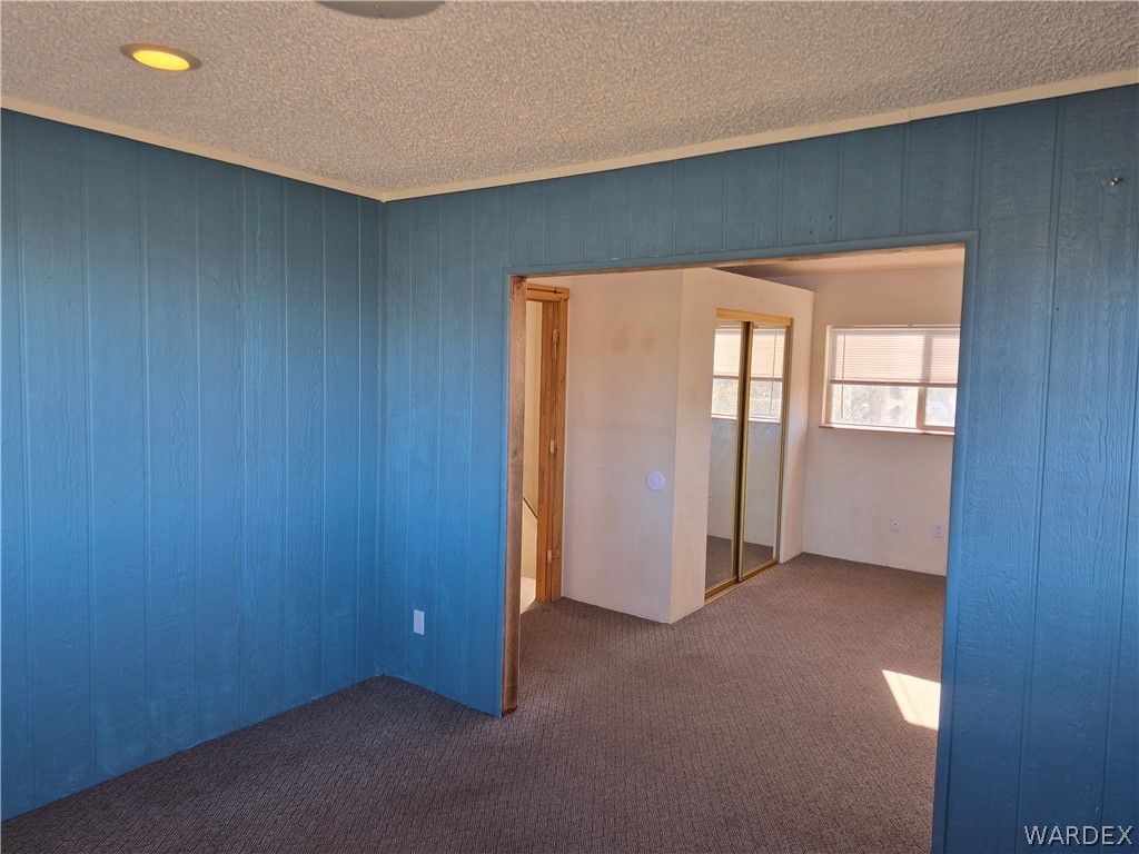 26432 Tamarisk Street, Unit STREET Meadview, AZ 86444 - Photo 26 of 60 Empty room with dark carpet, a textured ceiling, and recessed lighting