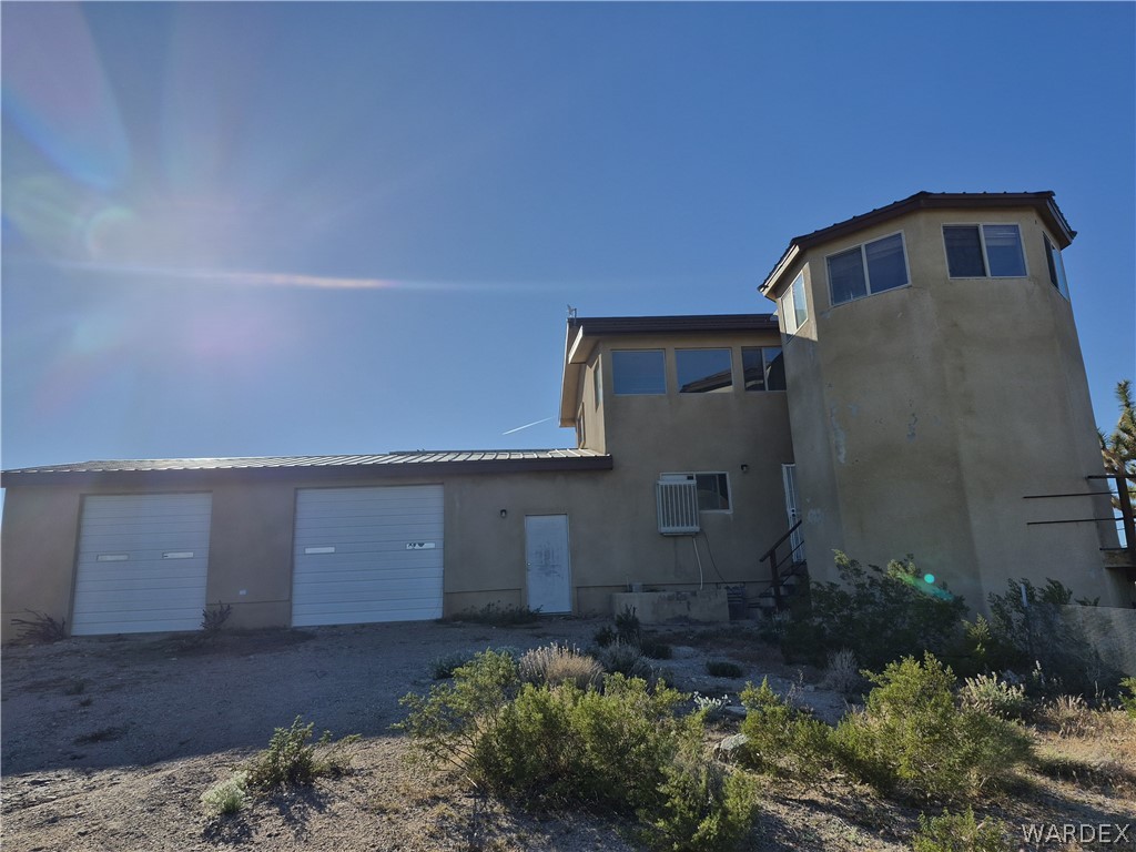 26432 Tamarisk Street, Unit STREET Meadview, AZ 86444 - Photo 39 of 60 Rear view of house featuring stucco siding and pull through driveway