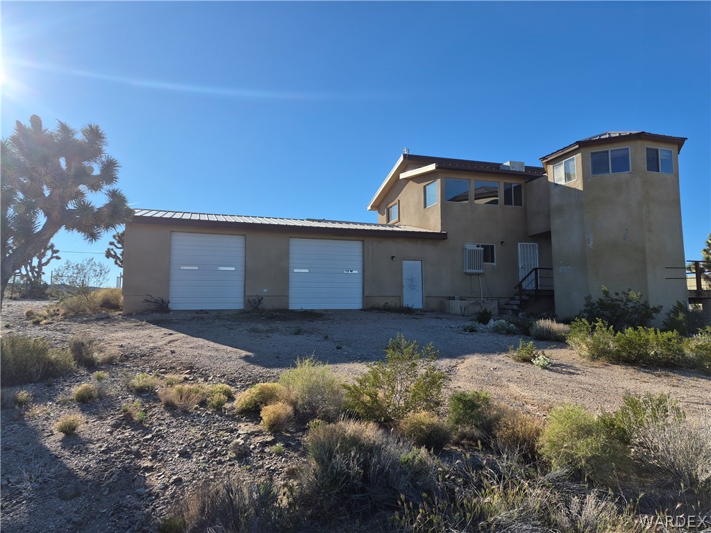 26432 Tamarisk Street, Unit STREET Meadview, AZ 86444 - Photo 41 of 60 Rear view of house featuring stucco siding and pull through driveway
