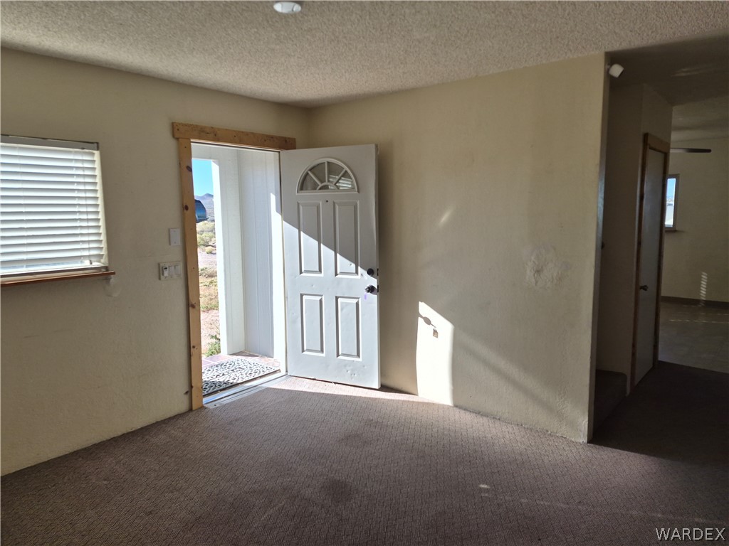 26432 Tamarisk Street, Unit STREET Meadview, AZ 86444 - Photo 3 of 60 Carpeted foyer featuring a textured ceiling