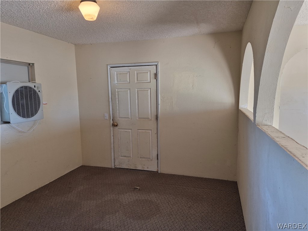 26432 Tamarisk Street, Unit STREET Meadview, AZ 86444 - Photo 7 of 60 Spare room featuring a textured ceiling and carpet flooring