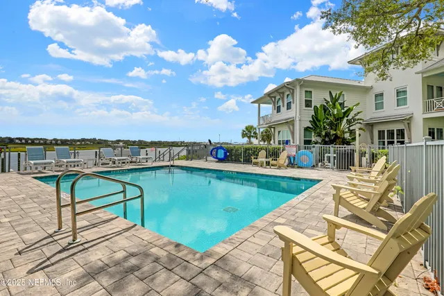 a kitchen with stainless steel appliances kitchen island granite countertop a refrigerator a stove a sink a dining table and chairs with wooden floor