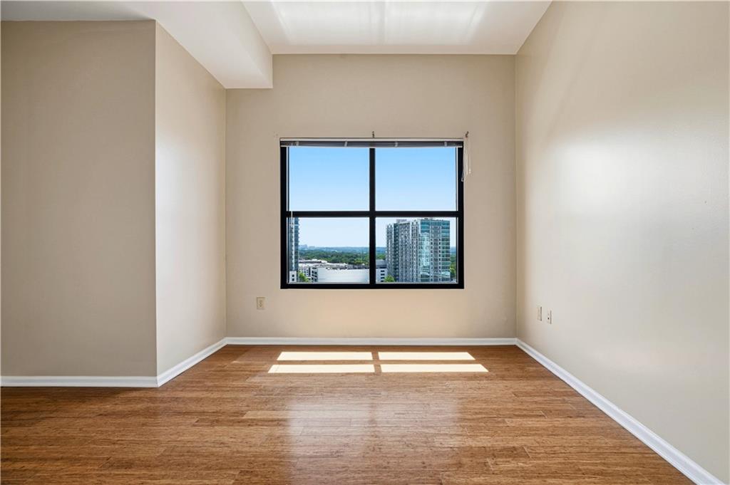 3040 Peachtree Road Northwest, Unit 1503 Atlanta, GA 30305 - Photo 21 of 38 a view of an empty room with wooden floor and a window