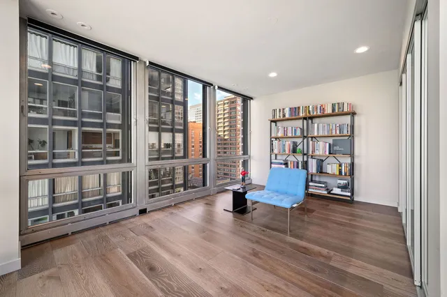 a living room with furniture hardwood floor and bookshelf