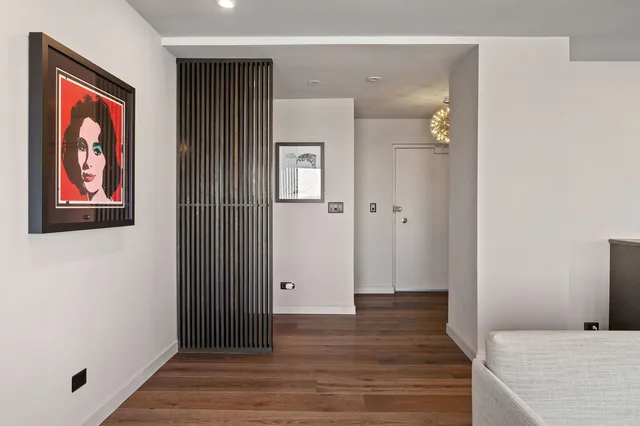 a view of a hallway with wooden floor and closet