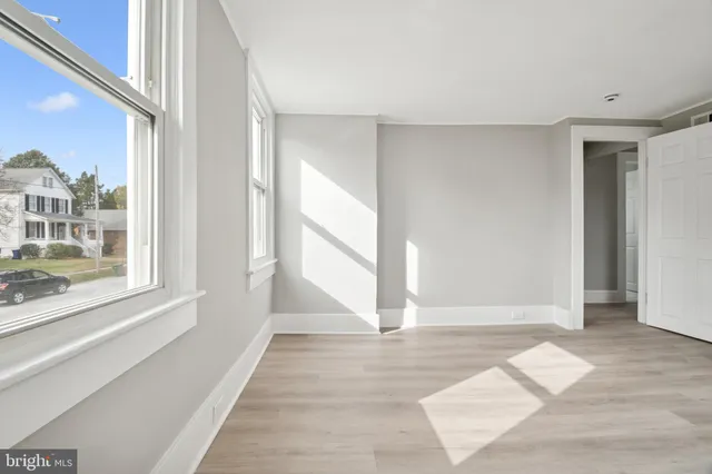 a view of a room with wooden floor and a window